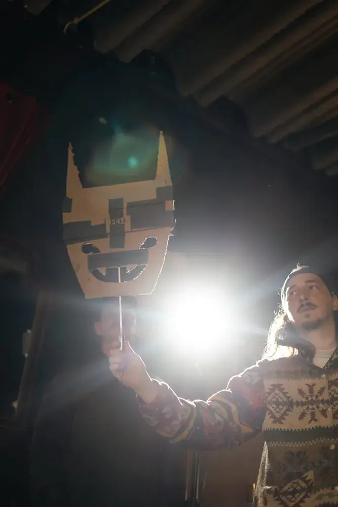 Mask prop lit by a hard backlight on set