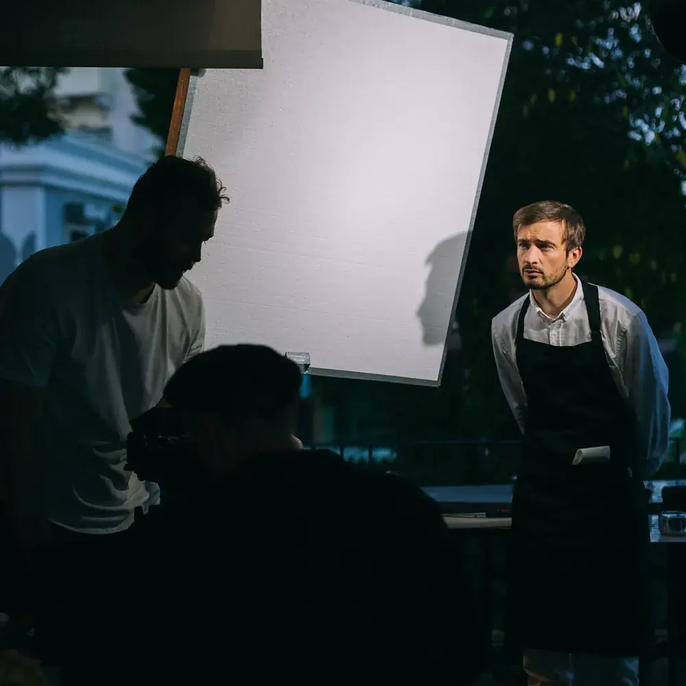 Actor in an apron waiting under a frame of diffusion