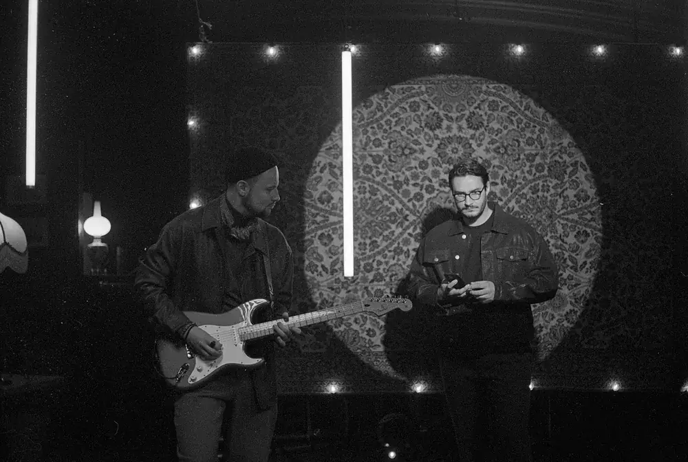 Guitarist and keys player between takes, black and white film photo