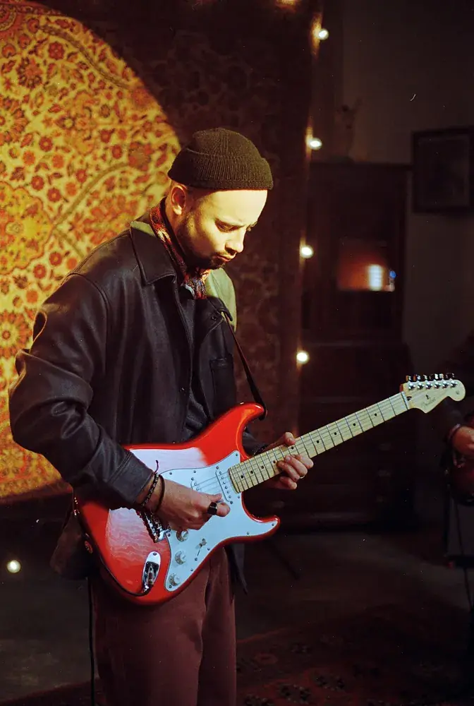 Guitarist playing a red Stratocaster during Po Fanku