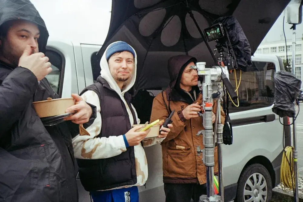 Comuna Production crew on a lunch break under an umbrella next to the camera, Lisbon