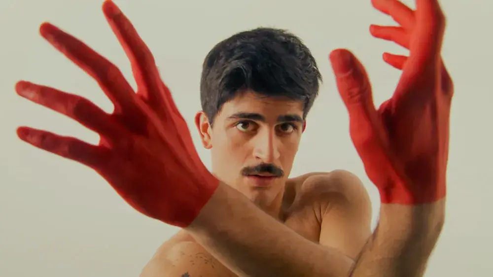 Red-painted hands framing the dancer's face